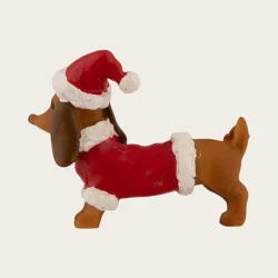 Gravhund med nissehue som dekorativ julefigur, 6 cm bred.