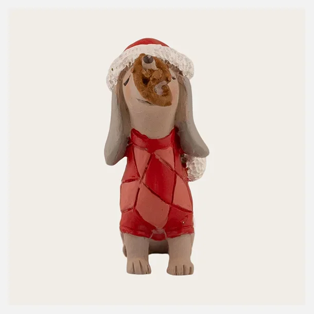Siddende julegravhund fra Det Gamle Apotek med kage balancerende p� snuden.